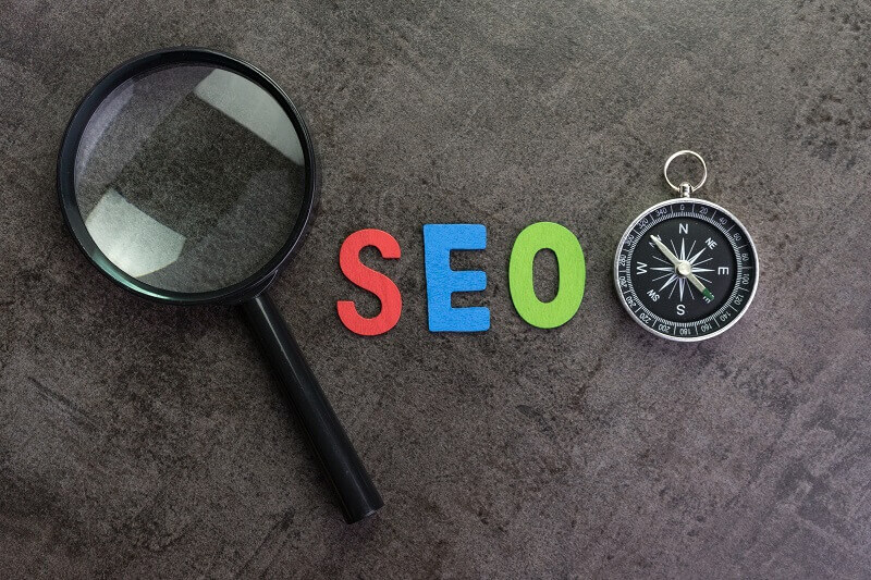 imagem mostra pula e bussola com a palavra SEO ao meio, com as cores do google